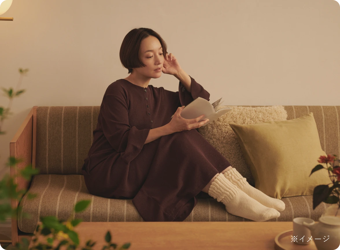 ソファでくつろぎながら読書を楽しむ、靴下を履いた足もと